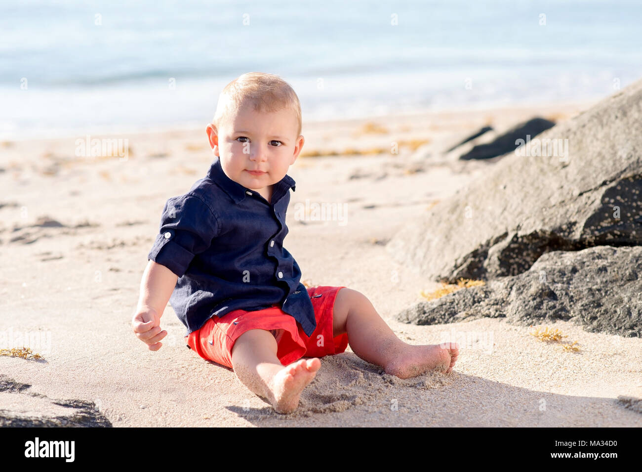 Little Smiling Boy Sitting Barefoot, Isolated On White Stock Photo, Picture  and Royalty Free Image. Image 6207823.