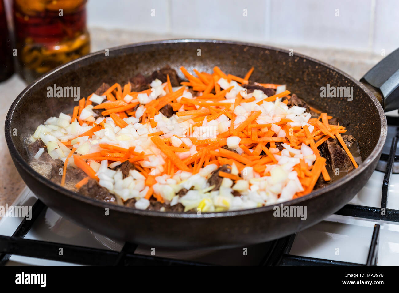 Close up beef meet stewed in skillet with vegetables Stock Photo