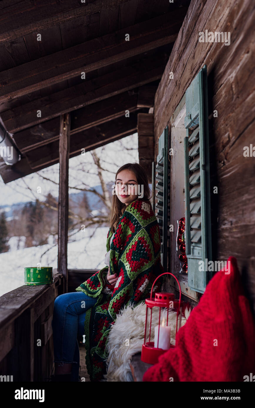 young woman,wrapped in a blanket sitting on the balcony,side view Stock ...
