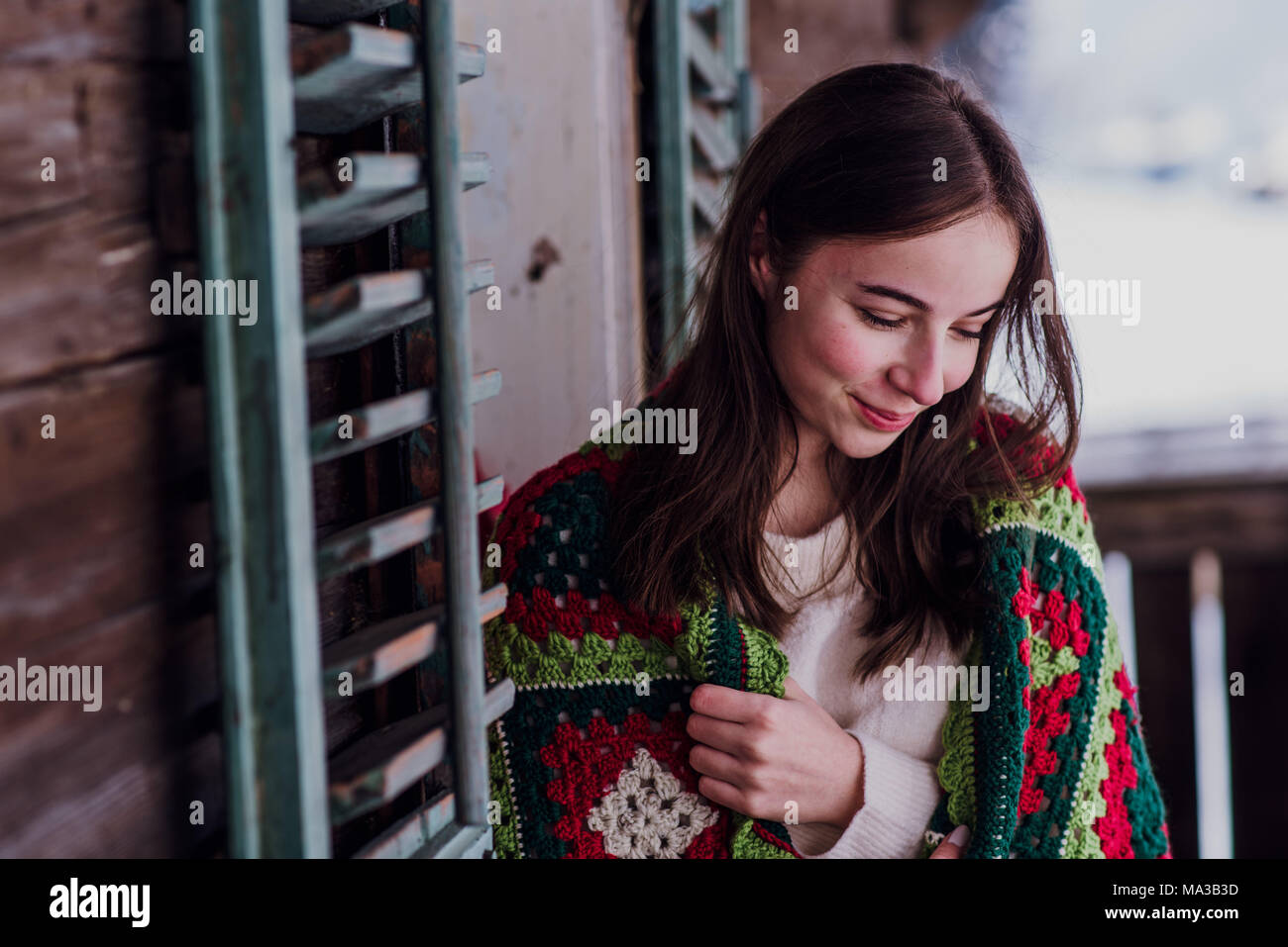young woman,wrapped in a blanket sitting on the balcony,portrait, Stock Photo