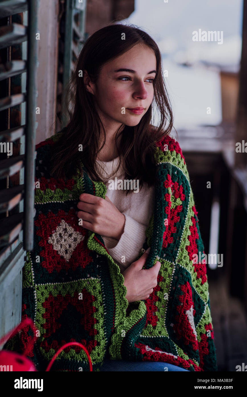 young woman,wrapped in a blanket sitting on the balcony,portrait, Stock Photo