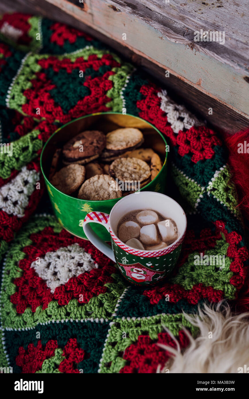 crochet blanket,cookie box,cup of hot chocolate with marshmallows Stock Photo