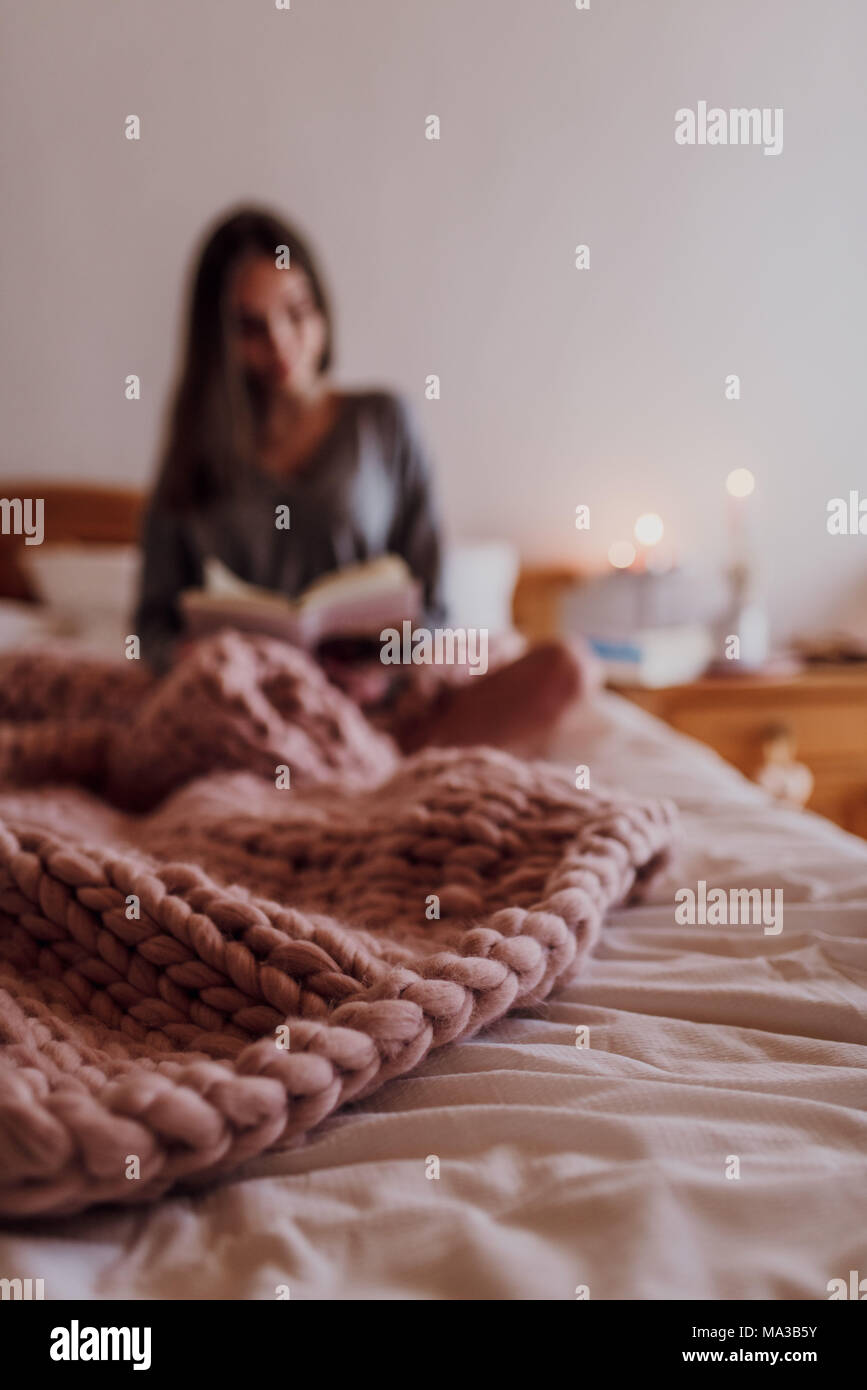 young woman sitting in bed and reading a book Stock Photo - Alamy