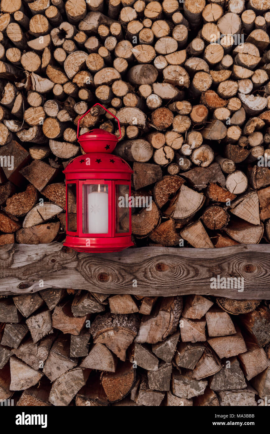 Red lantern in front of piled firewood Stock Photo