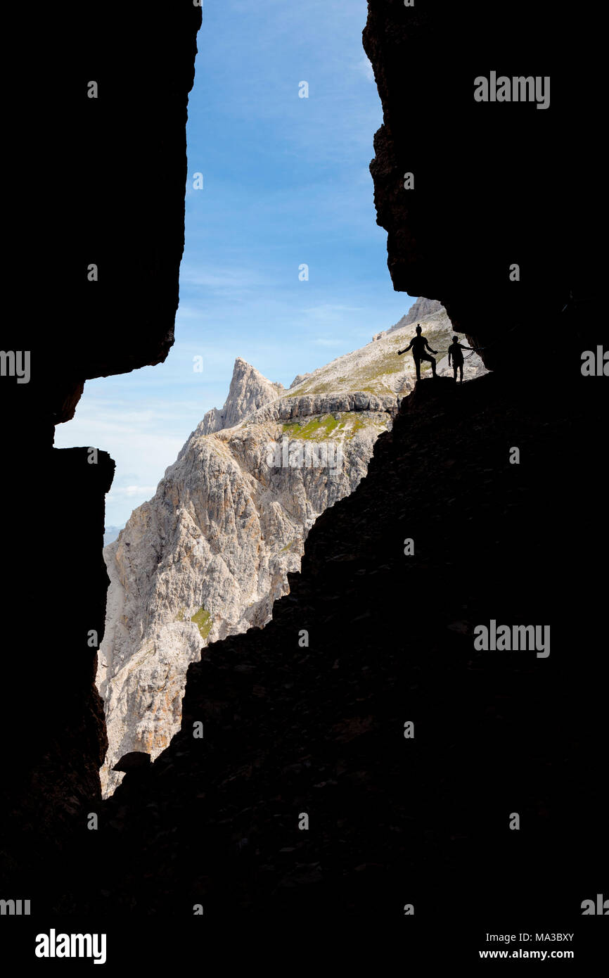Italy, South Tyrol, Sexten, Hochpustertal, Bolzano. Hiker in silhouette on the Alpinisteig or Strada degli Alpini via ferrata, Sexten Dolomites Stock Photo
