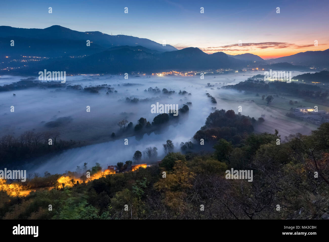 Mist over Adda river seen from Airuno at the Santuario Madonna della Rocchetta, Airuno, Parco dell'Adda Nord, Lecco province, Brianza, Lombardy, Italy. Stock Photo