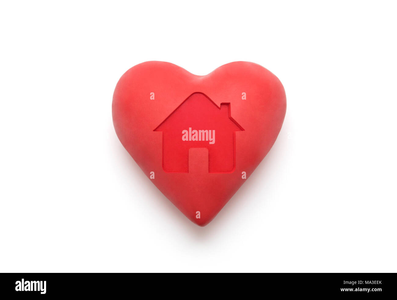 Red heart with imprinted house shape over white background with clipping path Stock Photo