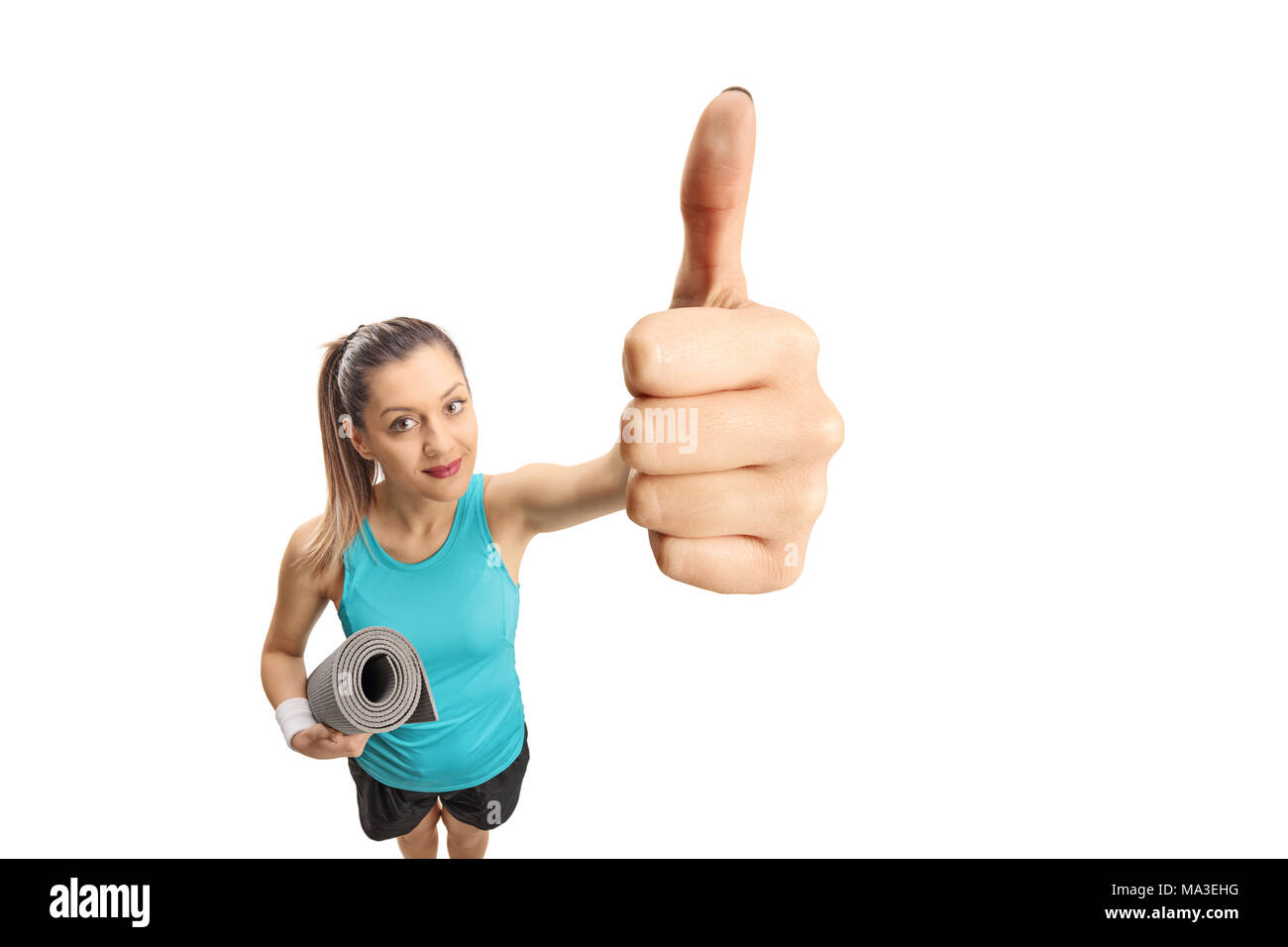 Fitness woman with an exercise mat making a thumb up sign isolated on white background Stock Photo