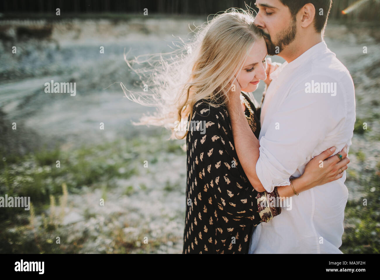 Couple in love standing on a meadow, hug, tenderness Stock Photo
