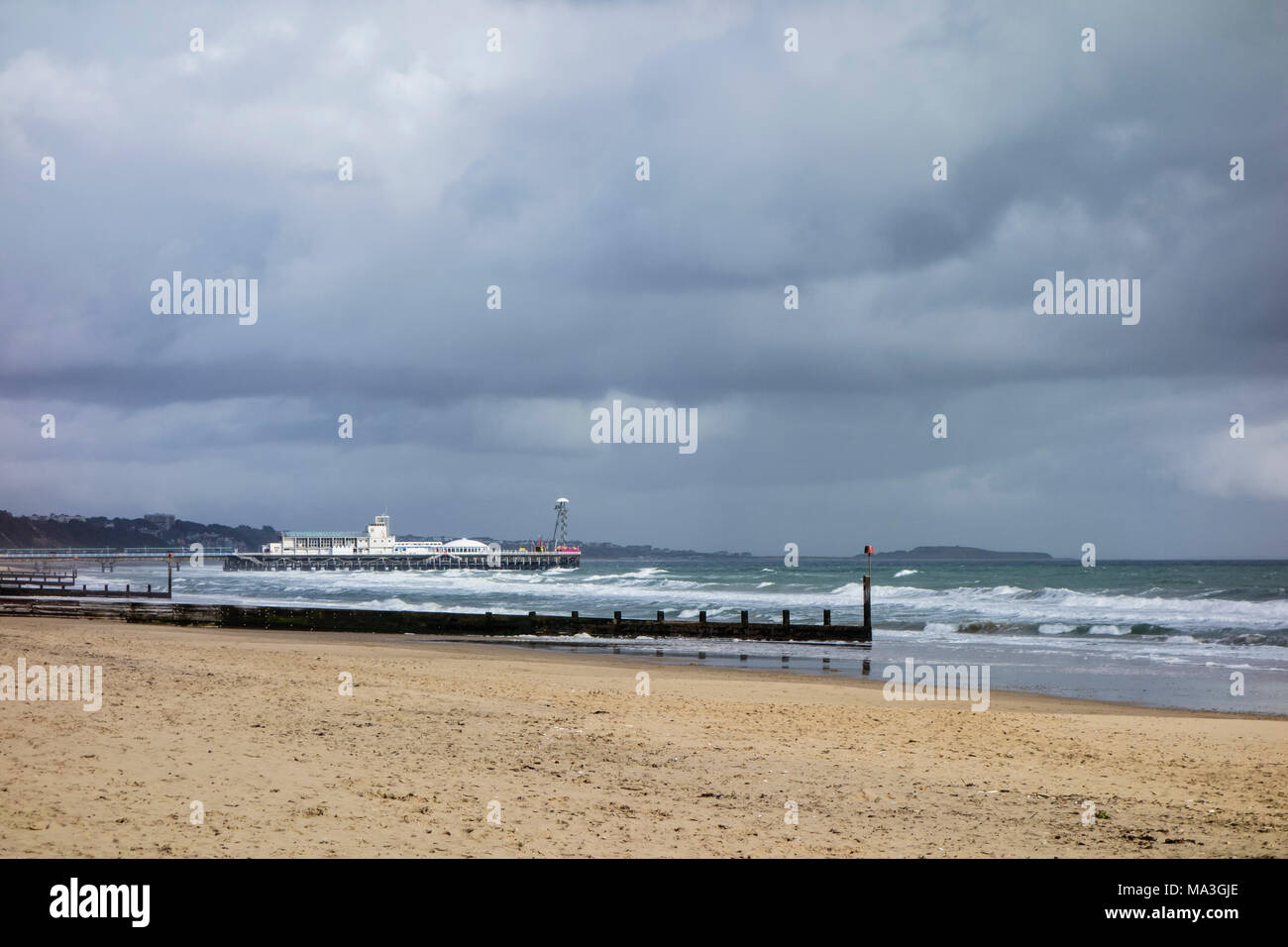 Bournemouth, UK. 29th March 2018. Deserted beaches with sunshine and showeres sweeping over Bournemouth Pier and Poole Bay. ©dbphots/Alamy Live News Stock Photo