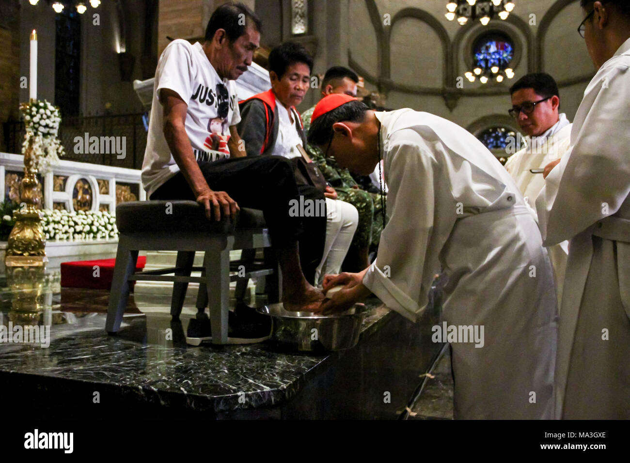 Manila Archbishop Antonio Cardinal Tagle washes the foot of the father of Joanna Demafelis, a Filipina worker in Kuwait killed by her employer. Cardinal Tagle officiates the Maundy Thursday  washing of feet mass at the Manila Cathedral. Stock Photo