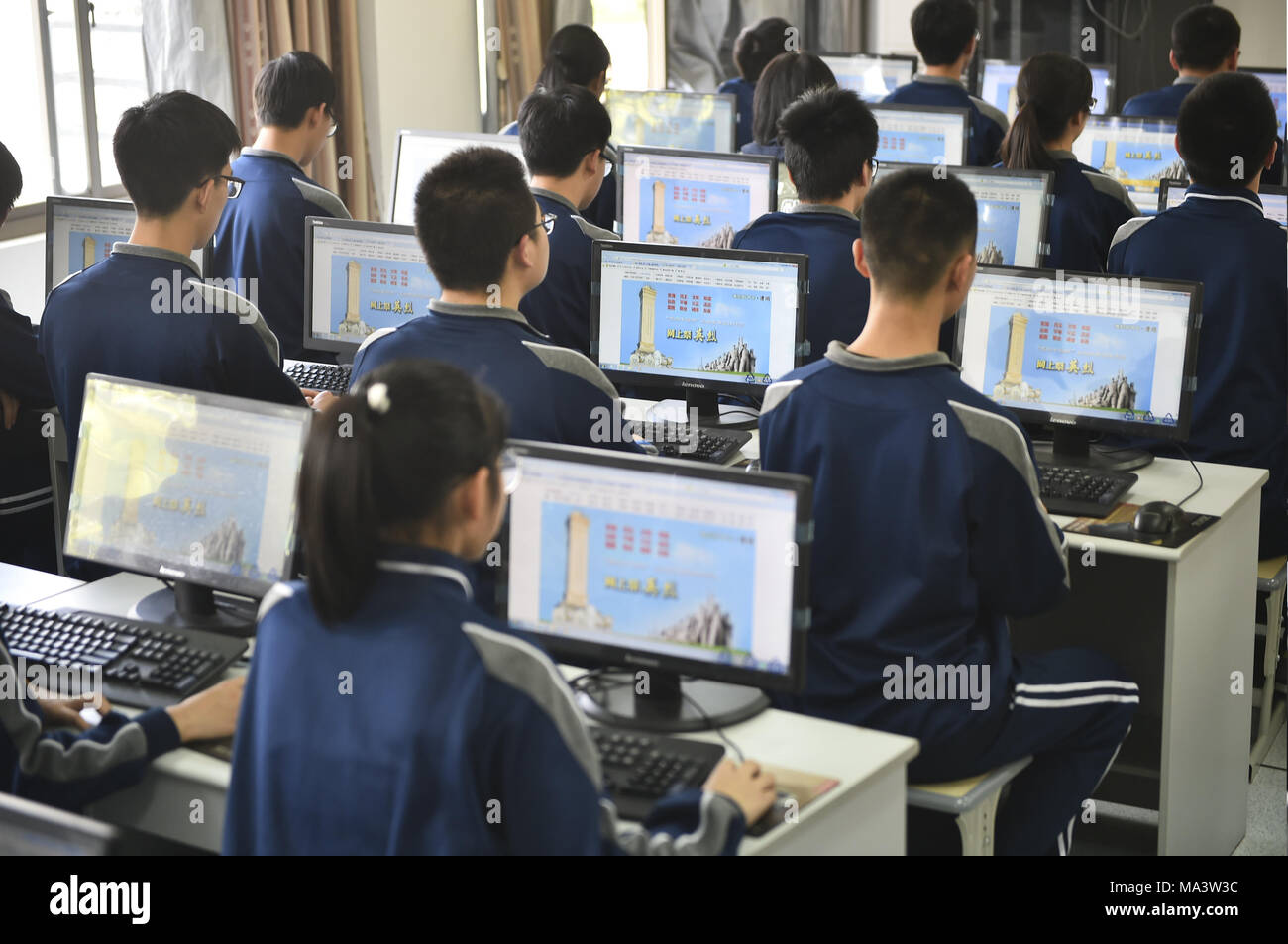 Tonglu, Tonglu, China. 29th Mar, 2018. Tonglu, CHINA-29th March 2018: Students attend online tomb sweeping activity at a middle school in Tonglu, east China's Zhejiang Province, worshiping martyrs. The Tomb Sweeping Festival, also known as Qingming Festival, has been a traditional Chinese practice for over 2500 years and falls on the 15th day of the Spring Equinox (usually 4th or 5th of April) over three days. In the most traditional sense, families gather together to worship their ancestors and provide maintenance such as cleaning, sweeping, repairing tombstones and placing flowers. (Credit Stock Photo