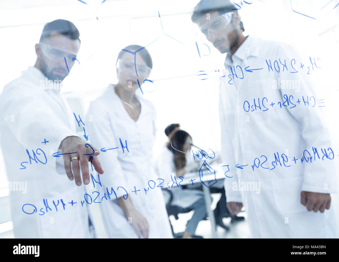 group of laboratory scientists discussing their research in the ...