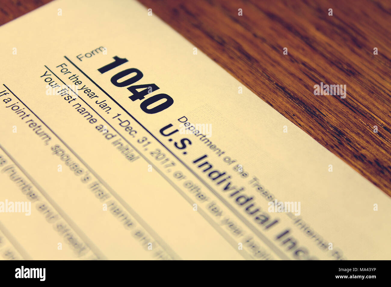 Tax day. The tax form 1040 is on a wooden table. Stock Photo