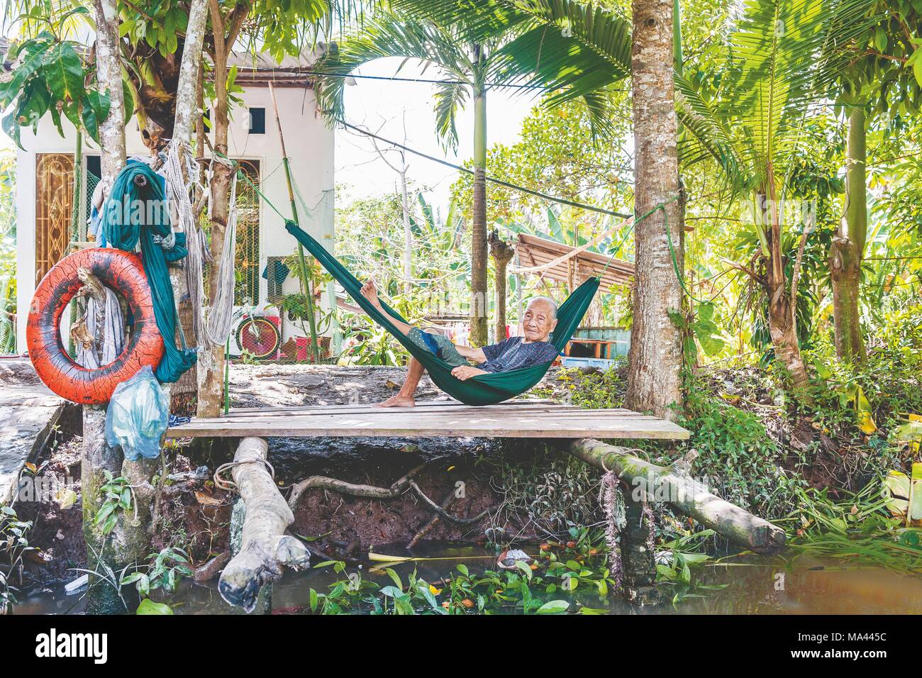 An old woman lying in a hammock on the Mekong Delta in Vietnam Stock ...