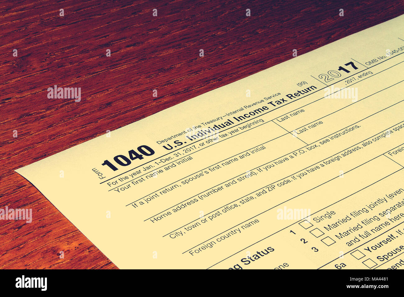 Tax day. The tax form 1040 is on a wooden table. Stock Photo
