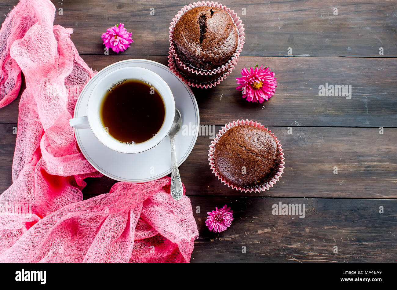 chocolate muffins and a cup of coffee breakfast  still life on a dark wooden table. Copy space, top view. Stock Photo