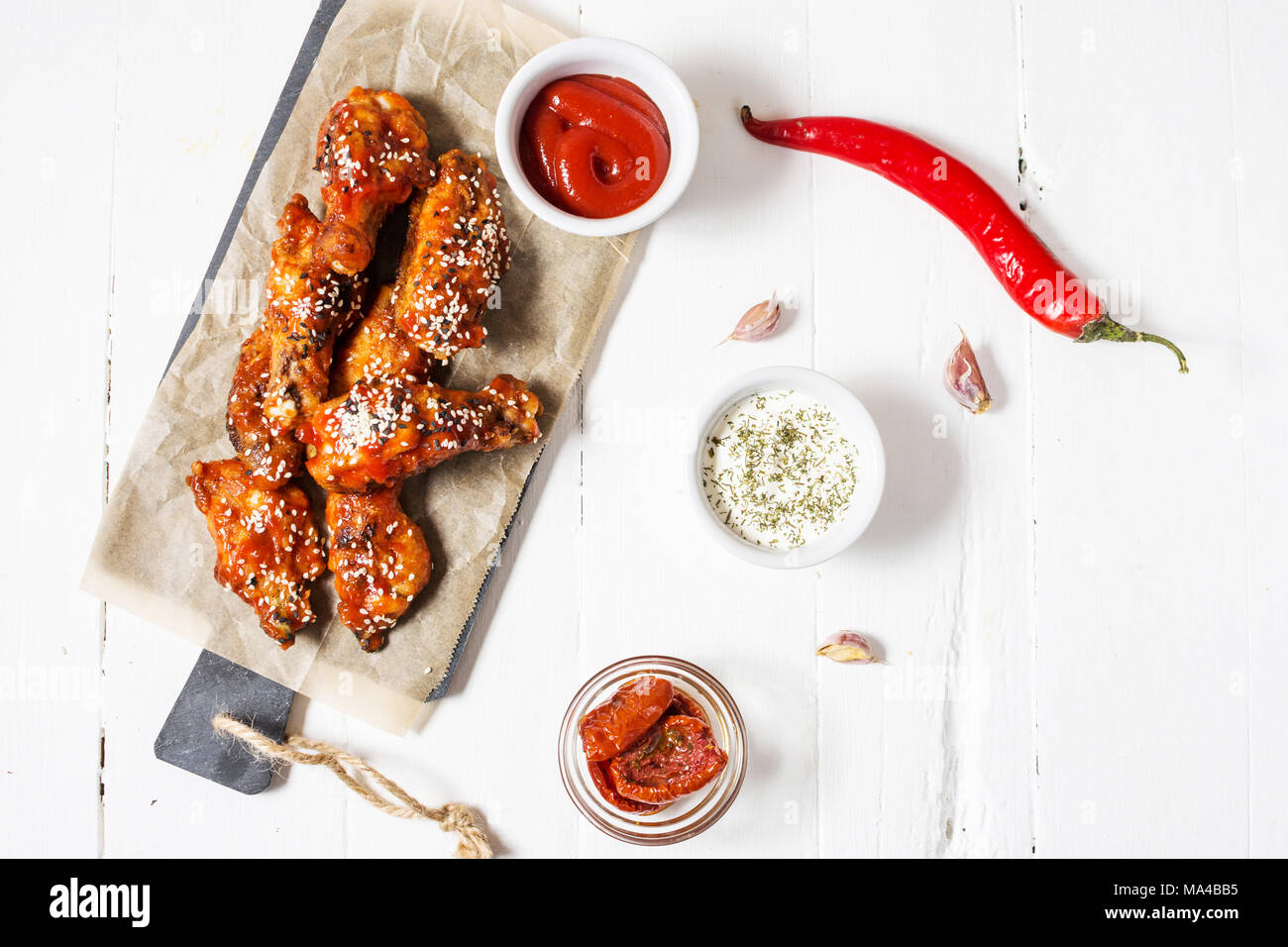 Baked chicken wings with sauce on white wood background . Copy space