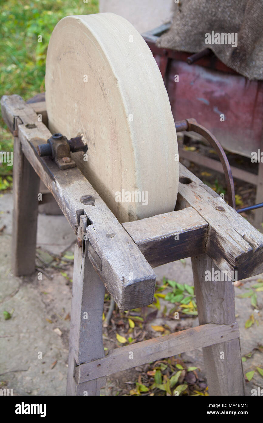 An old whetstone for sharpening knives. Grinding wheel on an old tripod.  Season of the autumn Stock Photo - Alamy