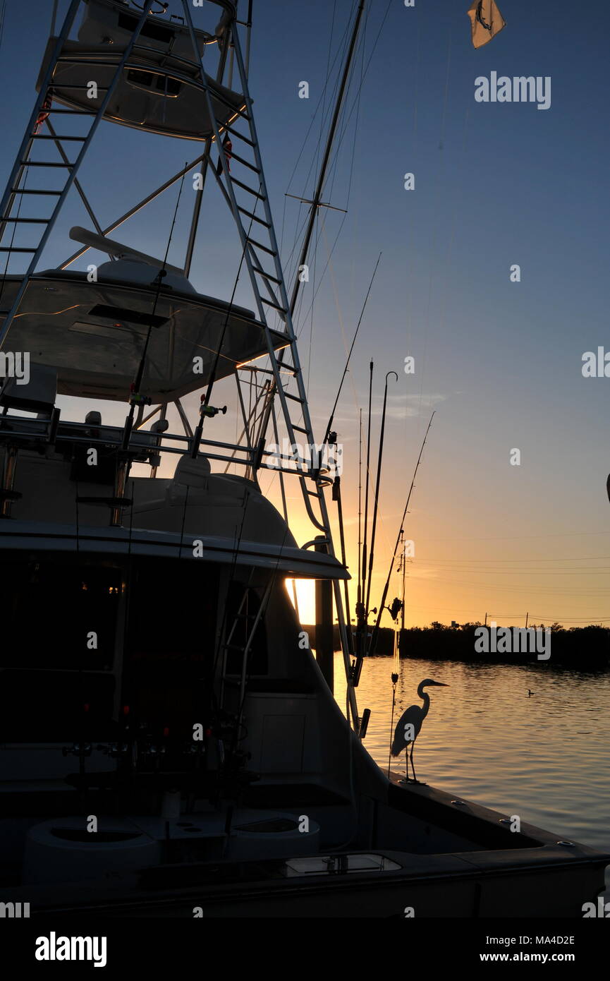 Deep sea fishing boat with rigging at sunset, docked in marina, with