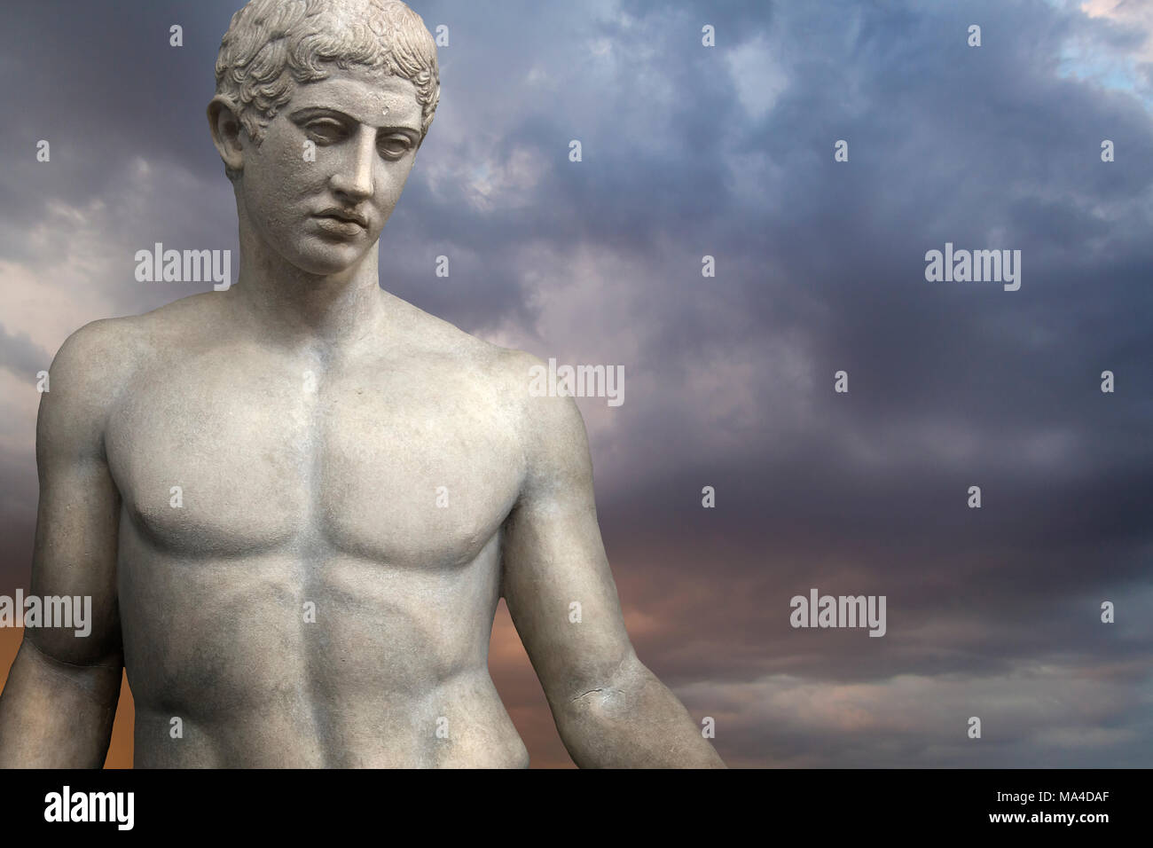 Greek Sculpture. Young Adonis bronze statue with blue sky background Stock Photo