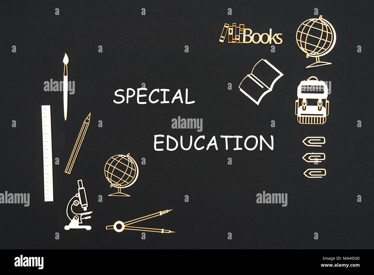 Wooden chipboard miniatures school supplies placed on blackboard with