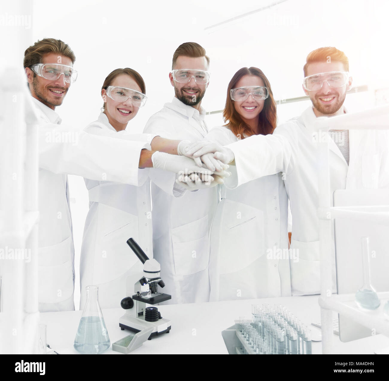 successful team of young scientists with hands clasped together.the ...