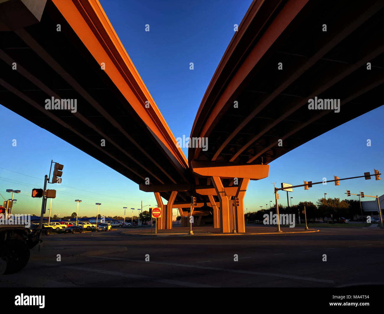 Looking up under the freeway in the early morning as two roads come together or split. Symbolize how in life one has to make some choices, go left or go right, but sometimes two views come together. Depends on which way you are going. Stock Photo