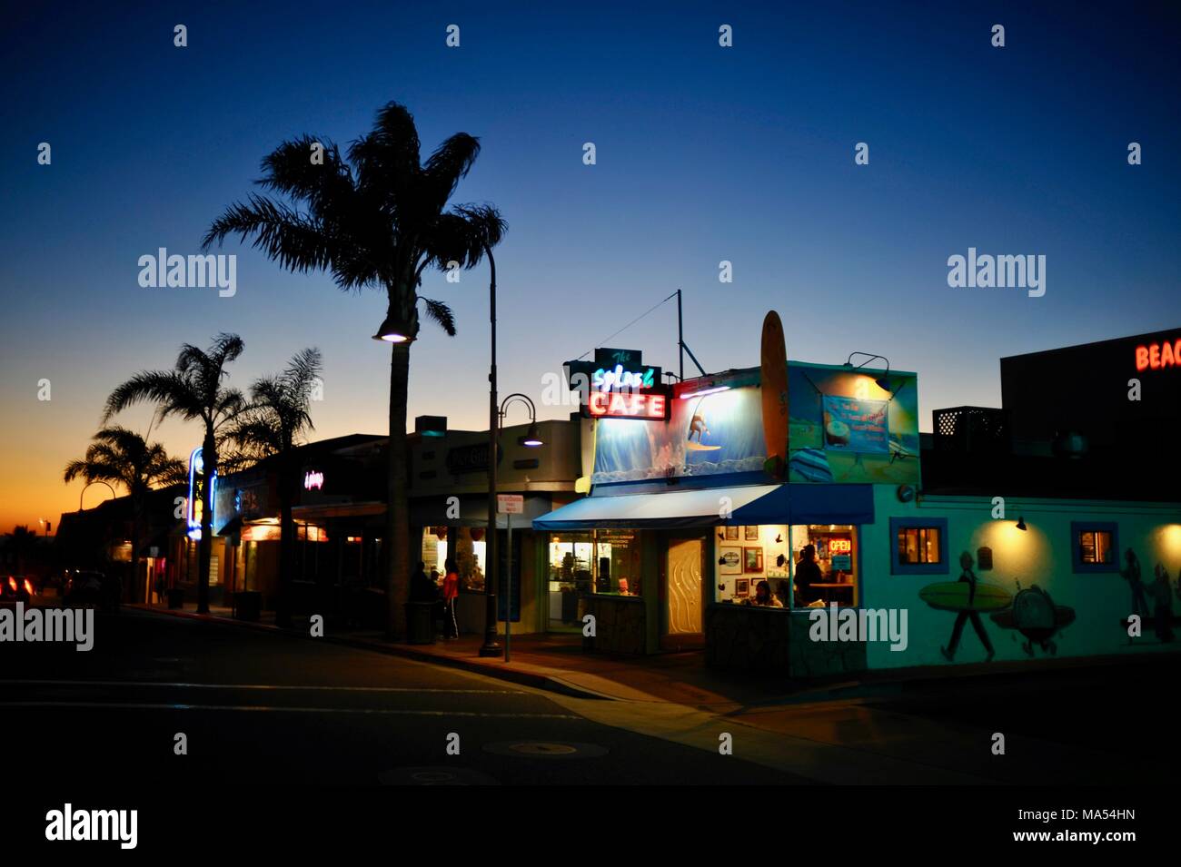 Popular Splash Cafe and silhouetted palm trees at sunset/twilight, in