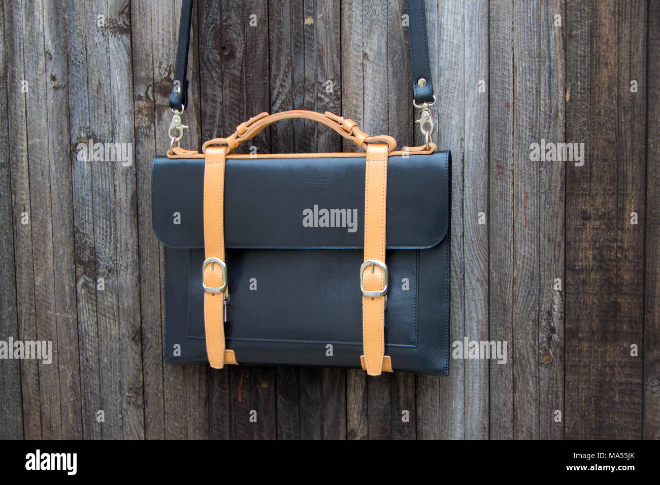 Lap top leather bag on wooden backrounde. Real leather Stock Photo