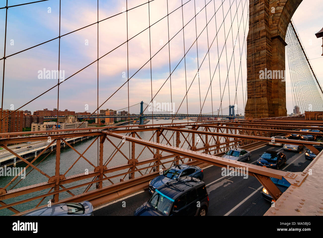 New York City, USA - June 08, 2015: Traffic including a New York Taxi crosses the bridge from Downtown Manhattan in the background toward Brooklyn. Stock Photo