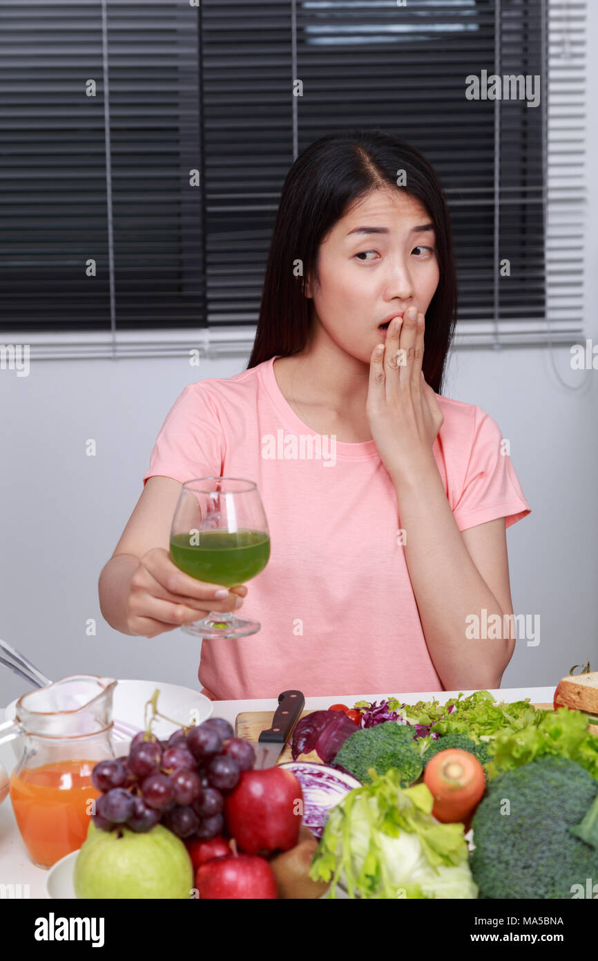unhappy young woman drinking vegetable juice in kitchen Stock Photo Alamy