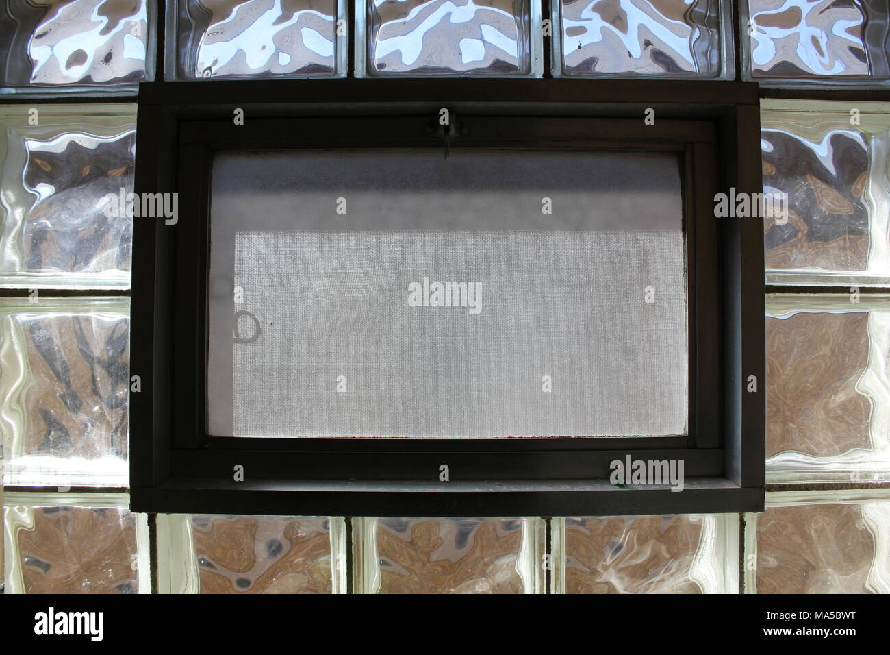 Vintage hopper window with frosted screen glass set in between swirling