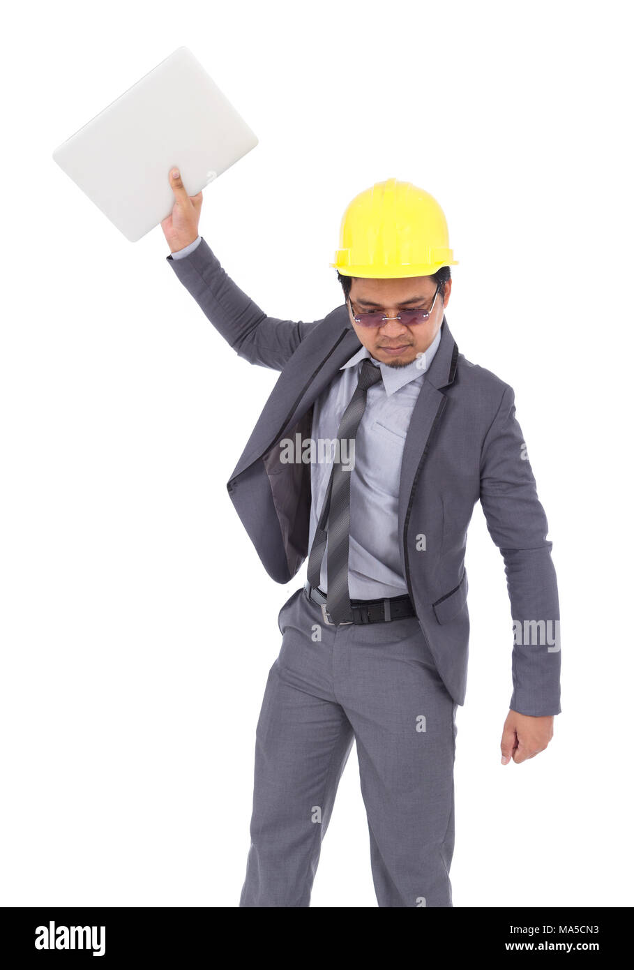 very angry engineer is throwing away his laptop isolated on a white