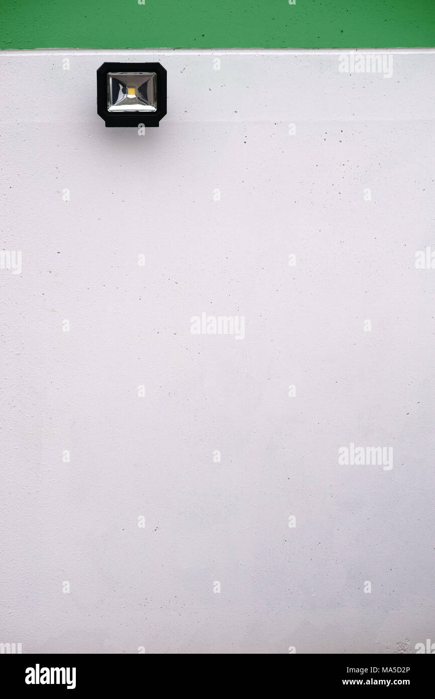 Close-up of a wall spotlight on a smooth bicolour concrete wall, Stock Photo