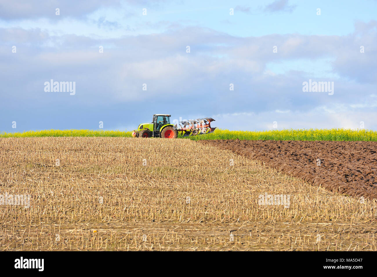 Tractor while ploughing a field Stock Photo