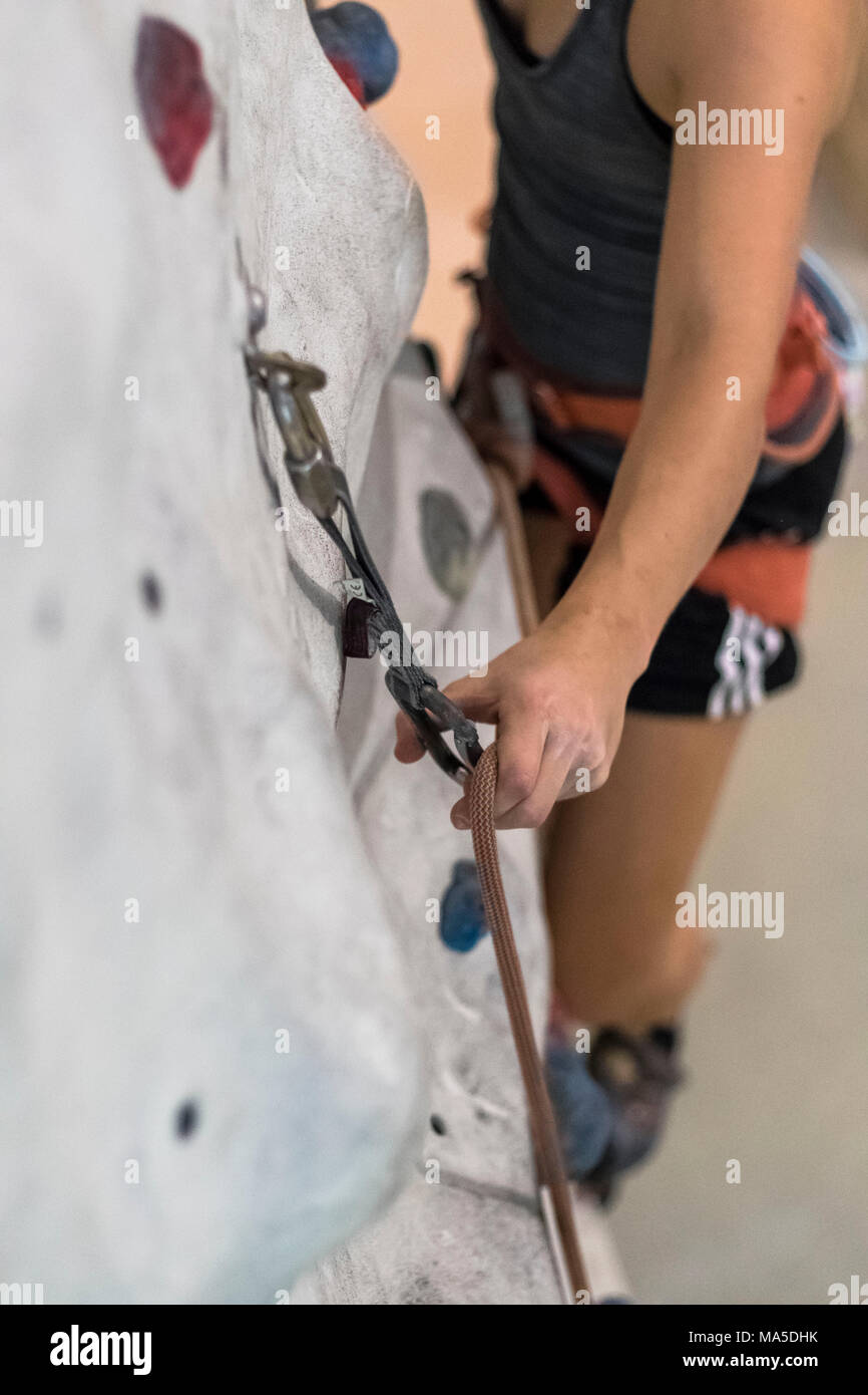 Female climber while hanging the rope in the lead hires stock