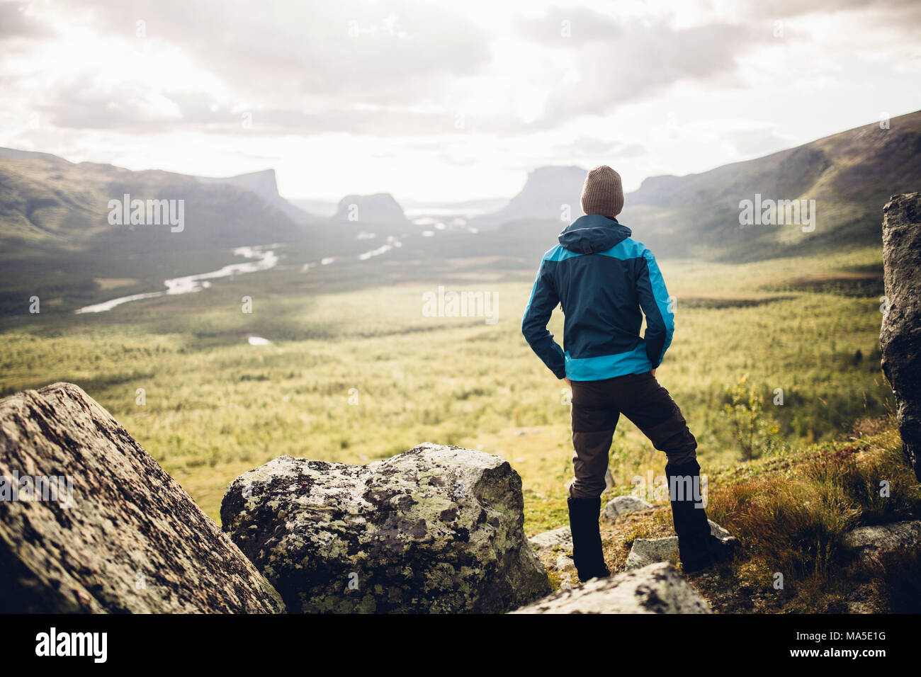 male hiker enjoys the view over the Rapadalen delta in Sarek National Park, Sweden Stock Photo