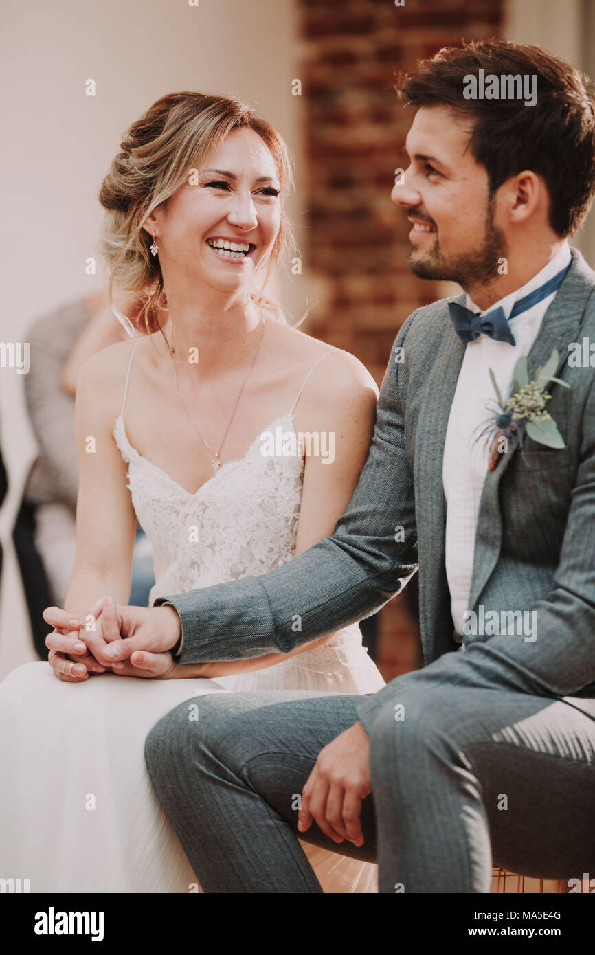 Bridal couple, sitting, holding hands, smiling, Stock Photo