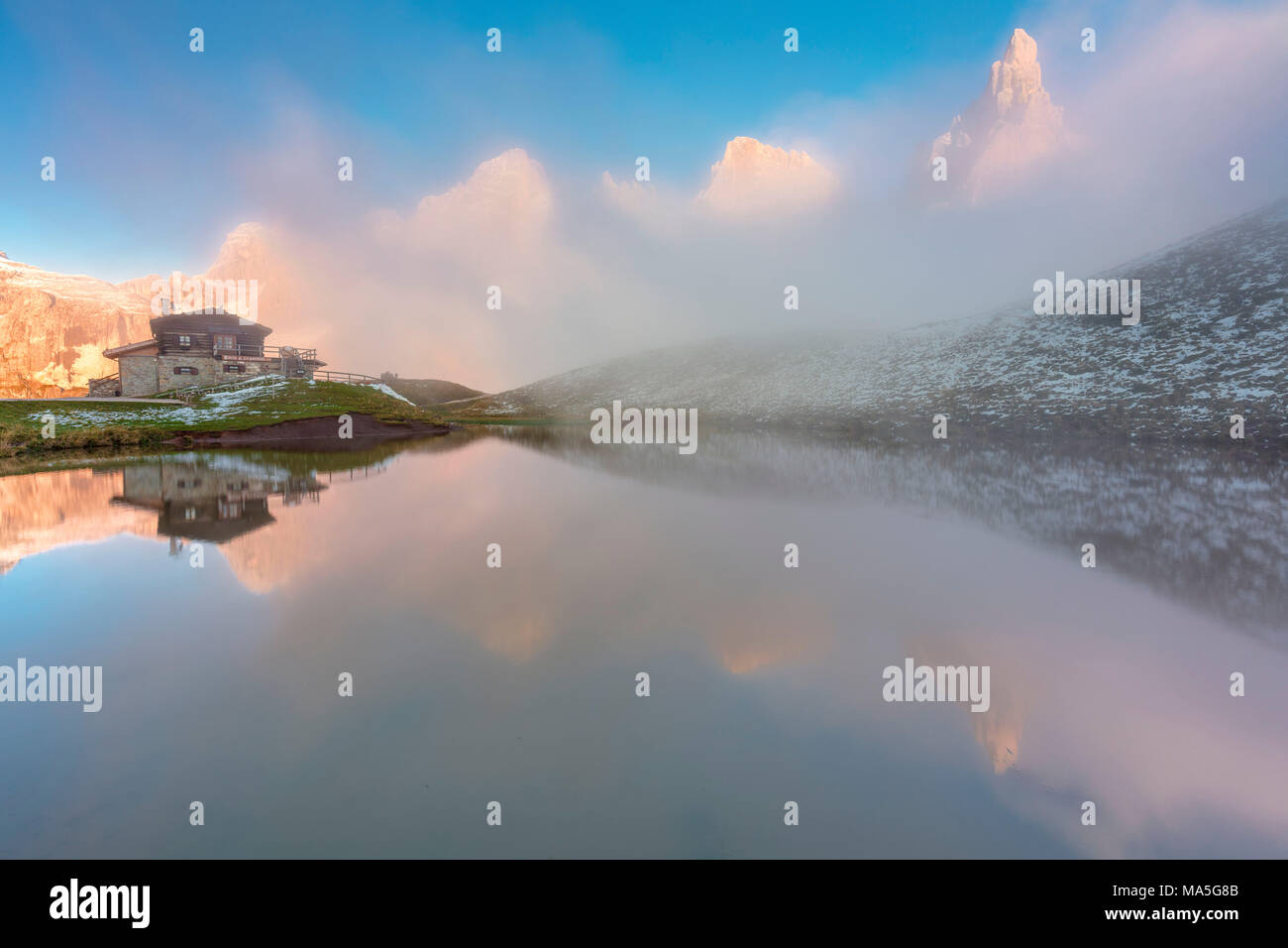 Dolomites Alps, Pale di San Martino reflecting on water with clouds, Baita Segantini, Trentino Alto Adige District, Italy Stock Photo