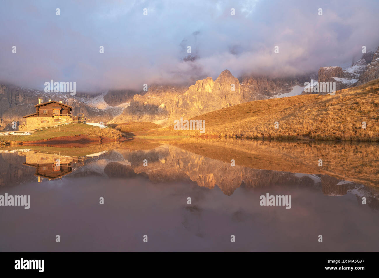 Dolomites Alps, Pale di San Martino reflecting on water with clouds, Baita Segantini, Trentino Alto Adige District, Italy Stock Photo