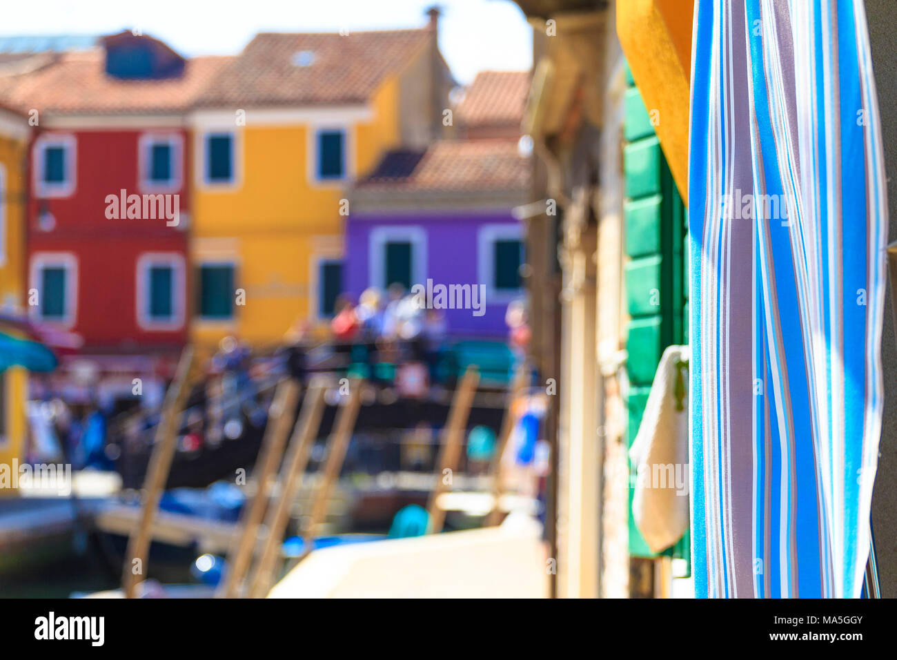 Volored curtain moved by the wind on a Burano canal, Venice, Veneto, Italy. Stock Photo