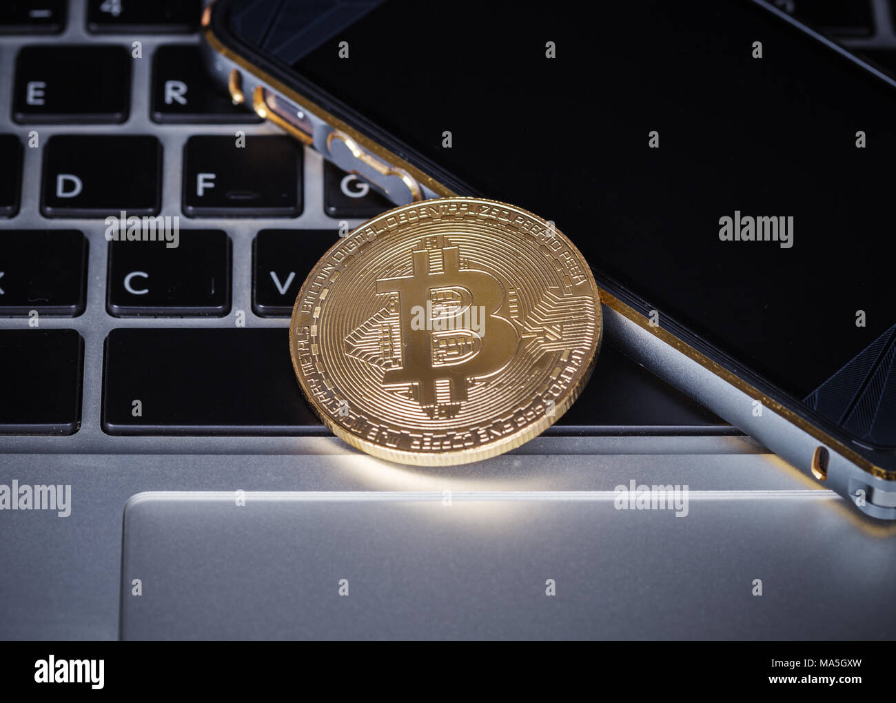 bitcoin with mobile on a laptop keyboard computer background Stock ...