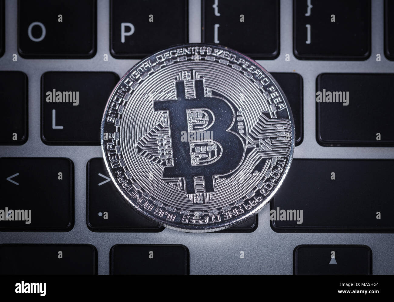 silver bitcoin on a laptop keyboard computer background Stock Photo - Alamy