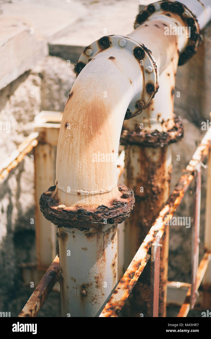 rusty tubes over stairs close to the Caribbean ocean Stock Photo