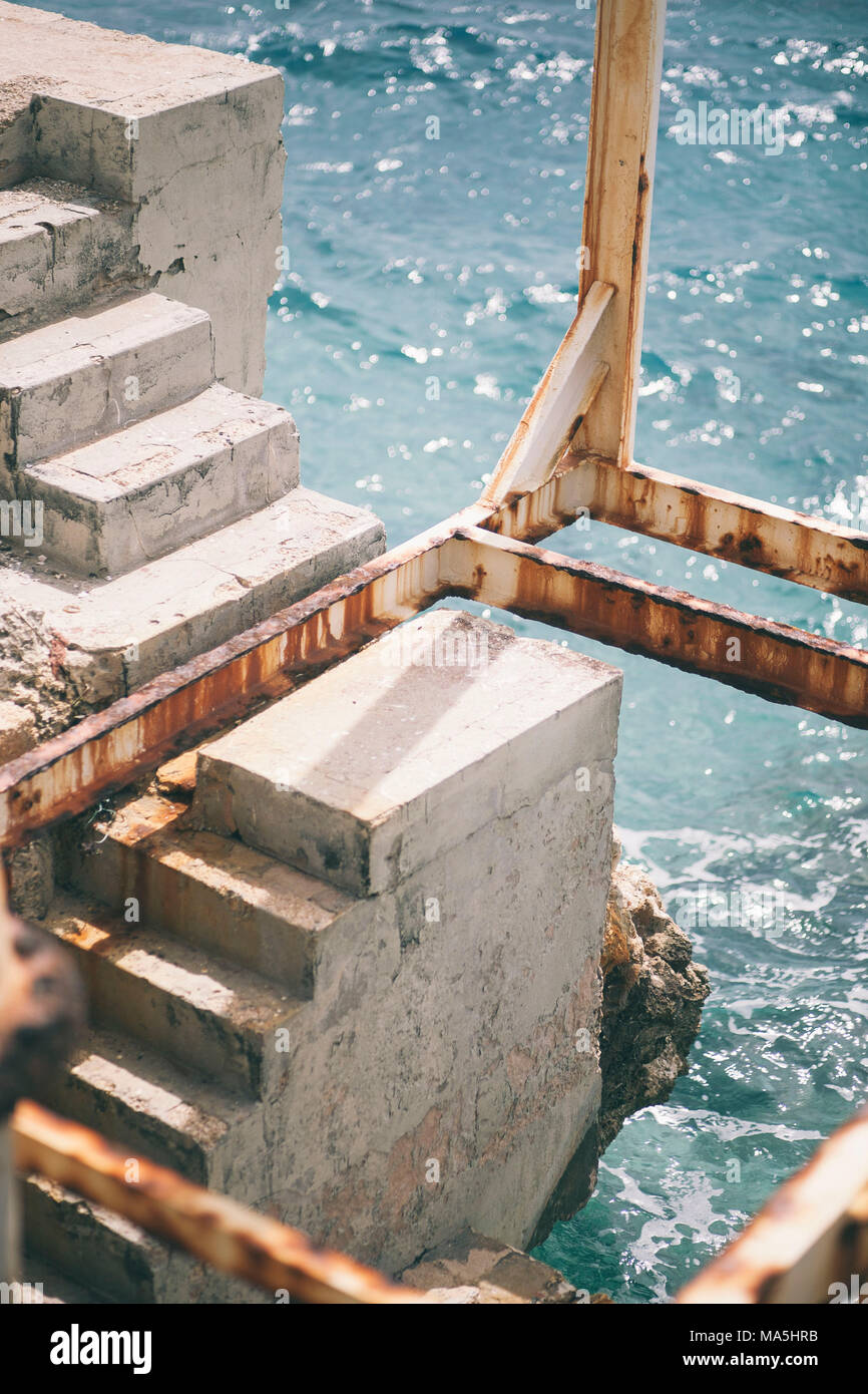 rusty iron bars over stairs close to the Caribbean ocean Stock Photo