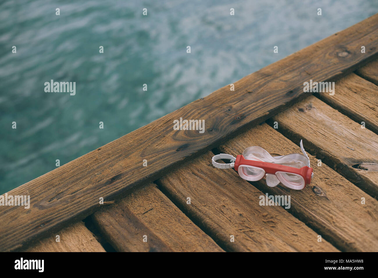 scuba dive mask on a dock close to the ocean Stock Photo