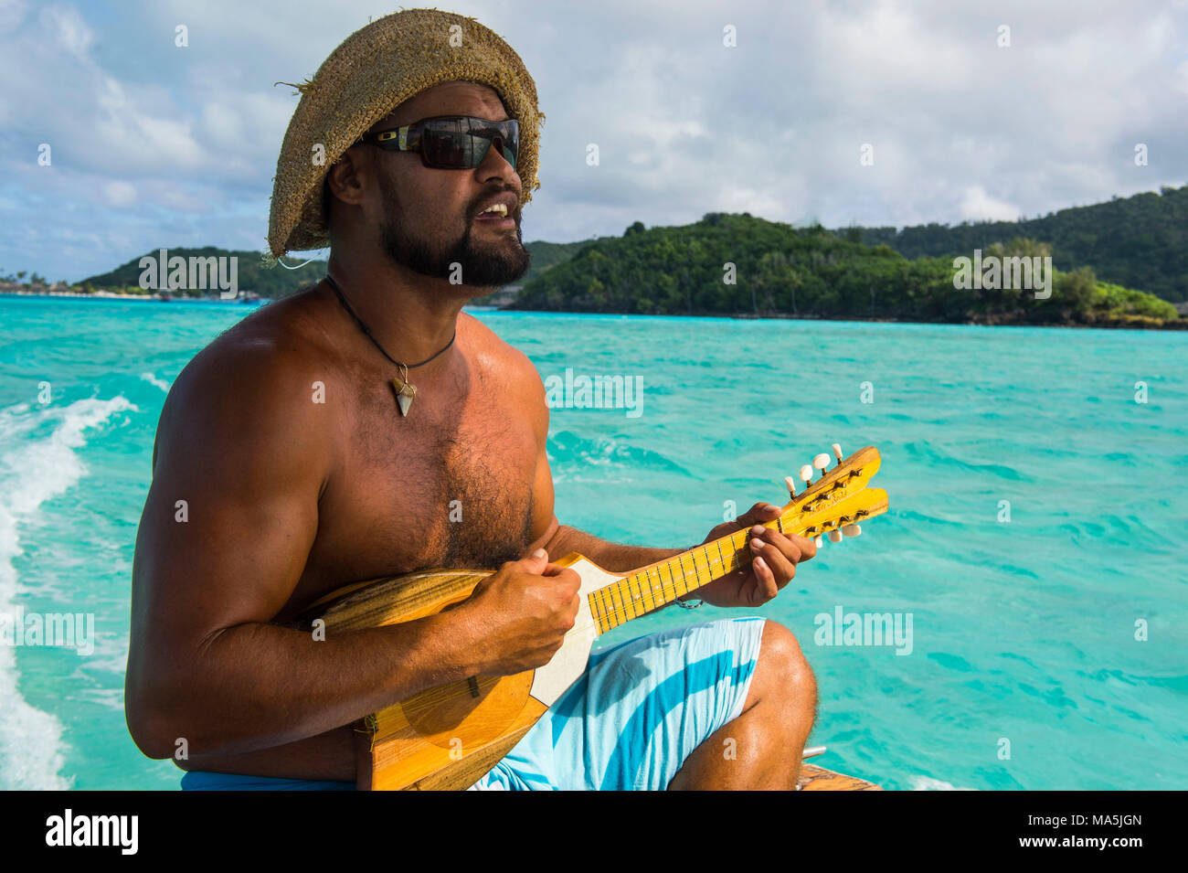 Local man playing the Ukulele, Bora Bora, French Polynesia Stock Photo