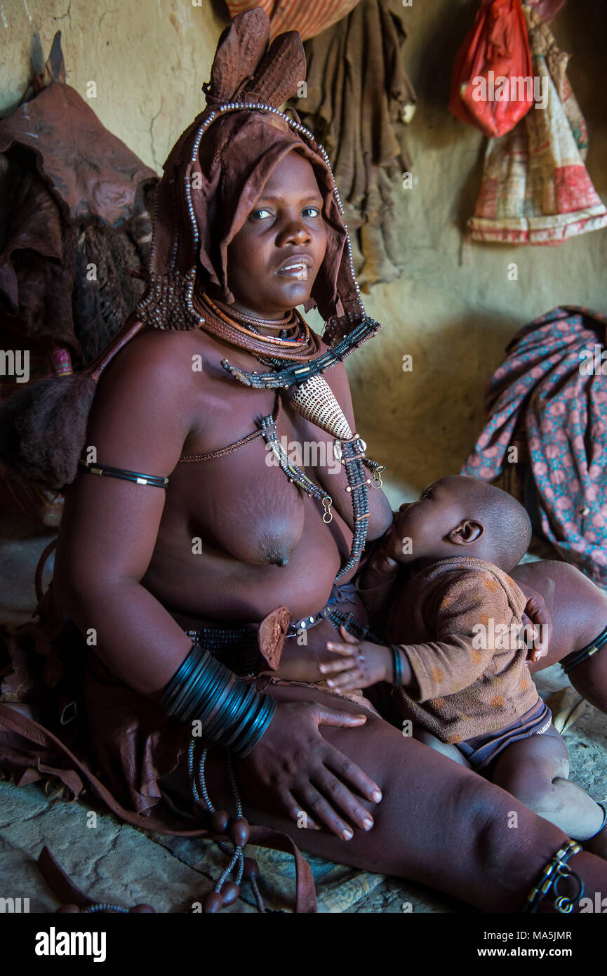 Himba woman breast feeding, Kaokoland, Namibia Stock Photo