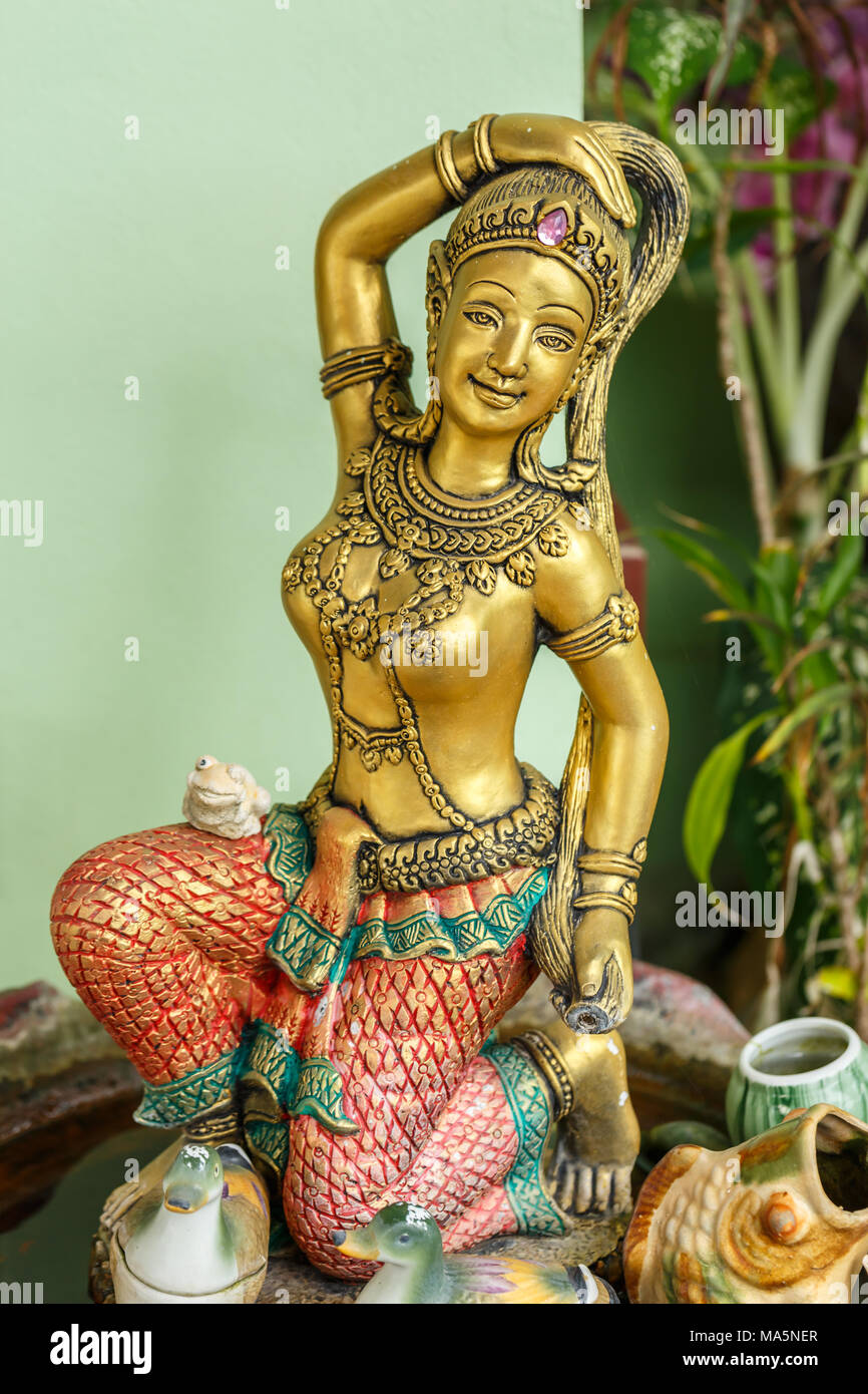 Statue of Phra mae thorani twisting her hair , the buddhist godness of earth - a statue in a temple area in Pattaya  Thailand Stock Photo